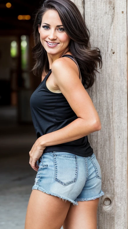 Courteney Cox wearing a tight low-cut shirt with ripped shorts and smiling
