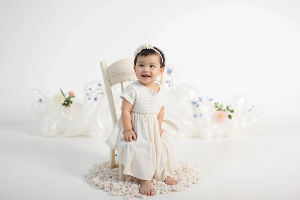 A 3 year old girl sits in an open room., smile, realistic, high resolution:1.3), white background