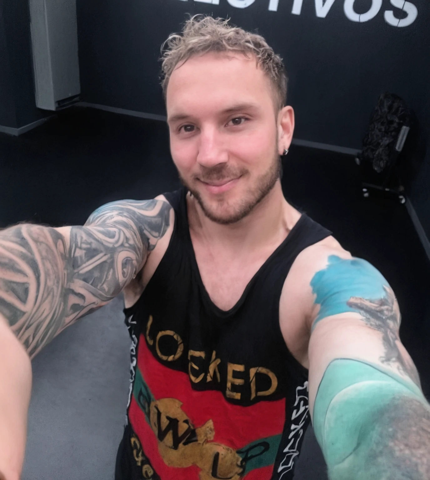 Anime Style, Gaming Room, Streaming Set-Up, Man with beautiful face, muscular physique, sitzt in einem Gaming-Stuhl, holds the gaming controller in his hand, Green eyes, schwarze wuschelige Haare, Kleidung im Stil von Tech-Wear, wears a black mouth mask, has tattoos all over her body and partly on her face.