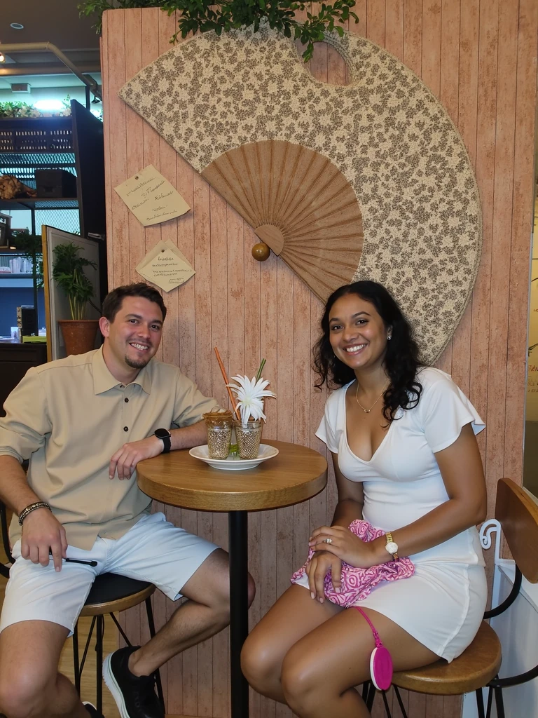 couple in love having a cocktail at a trendy restaurant, background and the vibe is young, fun, she is wearing a flower summer dress, he is wearing a casual tan shirt and jeans