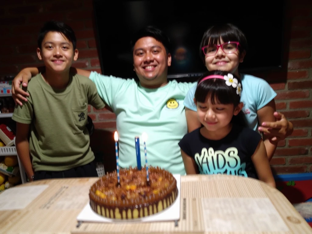 People celebrating the birthday of a 17-year-old boy, with a big cake that has the name Piero.