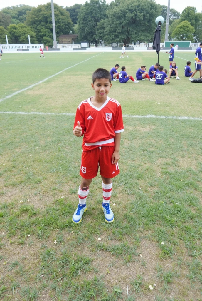 a smiling boy in a soccer uniform, in the middle of a game. bottom: a school field.