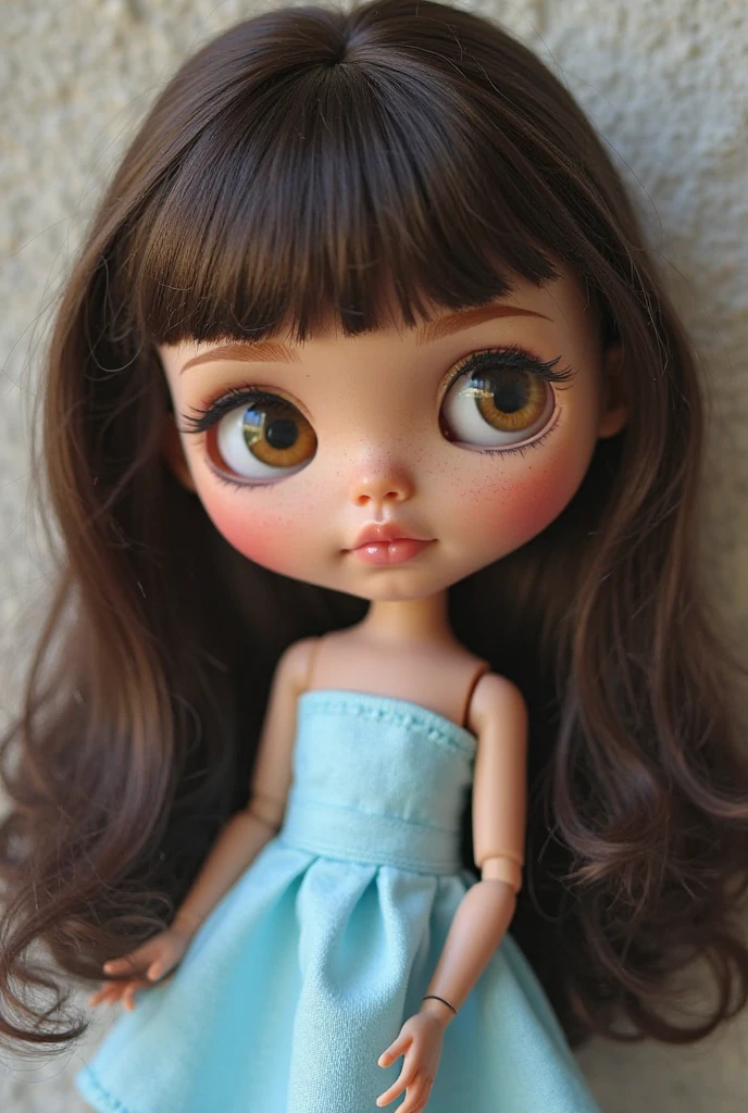 Blythe doll, with large dark brown eyes, short curly dark brown hair, light brown skin, rosy cheeks and freckles, with light blue background