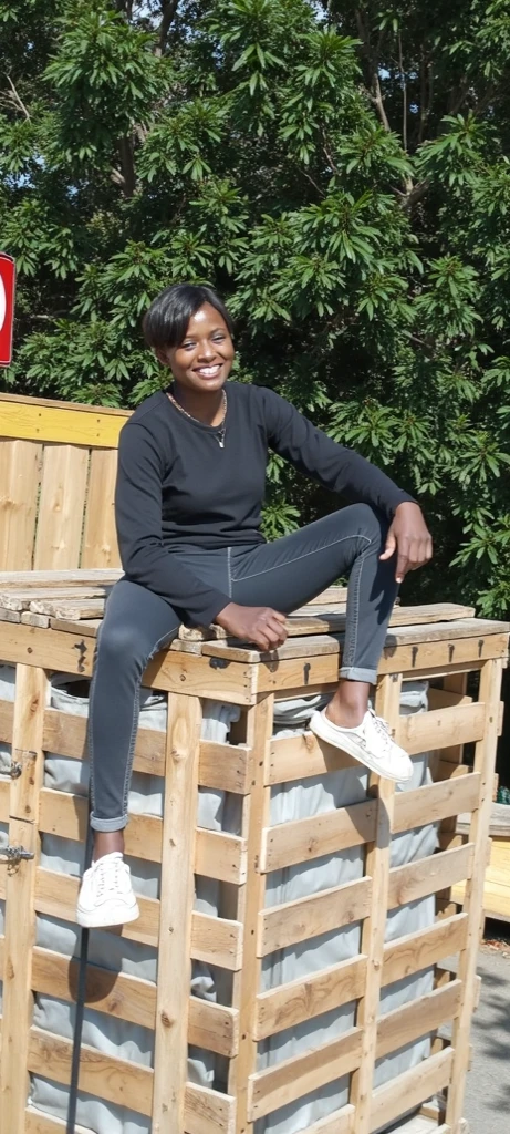 The image depicts a vibrant and cheerful scene of a person actively engaged in a tree planting initiative. The foreground features an individual holding a small plant, smiling and dressed in a white headwrap and sleeveless shirt. In the background, there is a vast field filled with numerous potted plants, illustrating a large-scale planting effort. The temperature icon at 50°C suggests a hot climate, while the text "100000 TREE'S" with an arrow emphasizes the planting of a hundred thousand trees. The clear sky indicates a sunny day. Overall, the image conveys a positive and enthusiastic message about a significant tree planting project in challenging weather conditions.