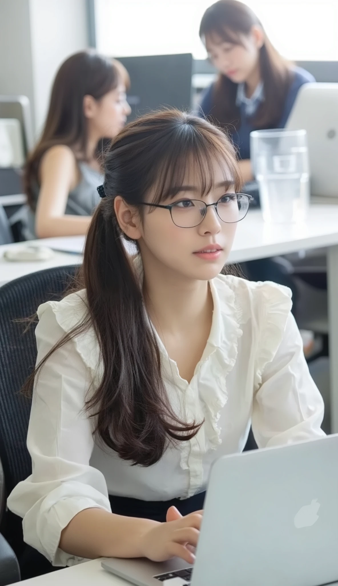 A photorealistic image of a young Japanese woman in her 20s sitting at her desk in a busy Tokyo office. She is viewed from the side, full body visible, as she works on her laptop. She has long black hair tied with a hair clip, wears glasses, a white frilled blouse, and a black mermaid-line skirt. She is sitting upright in an office chair, focused and composed. The camera is positioned at her side, showing her entire figure and desk clearly. The viewer is not shown in the image. The office is bright and filled with other employees working at their desks in the background.