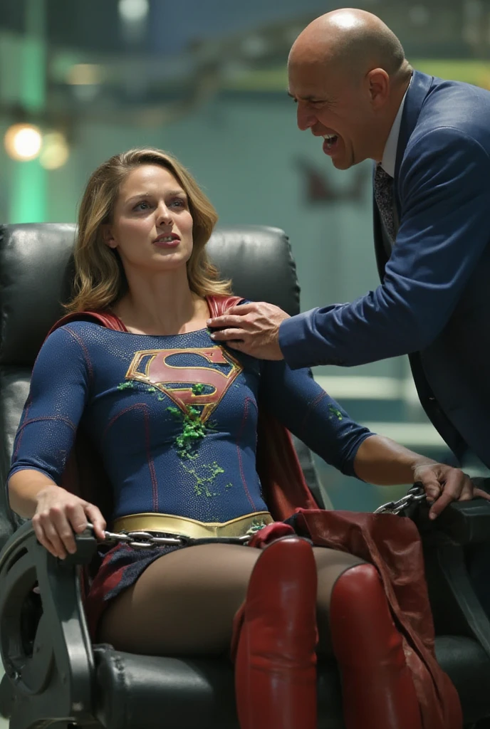 Supergirl, defiant and angry but helpless, chained to a chair in a mad ...