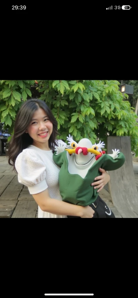 A little girl with white skin and orange clothes，Take a photo with the duck sculpture in front of the flower bed as you play at the amusement park，
