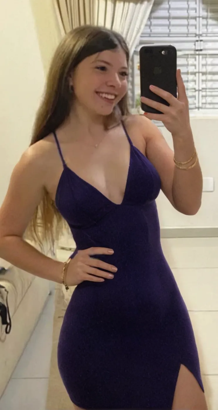 a selfie of a pretty latin young woman at a party with a purple dress