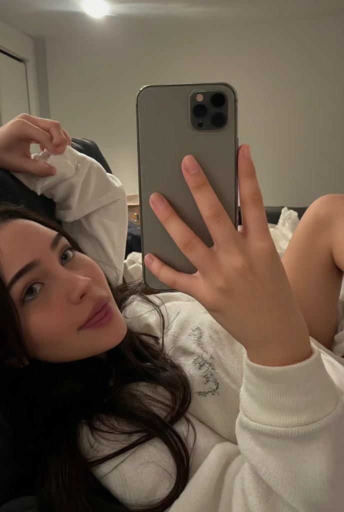 Woman lying in bed in pajamas taking a selfie