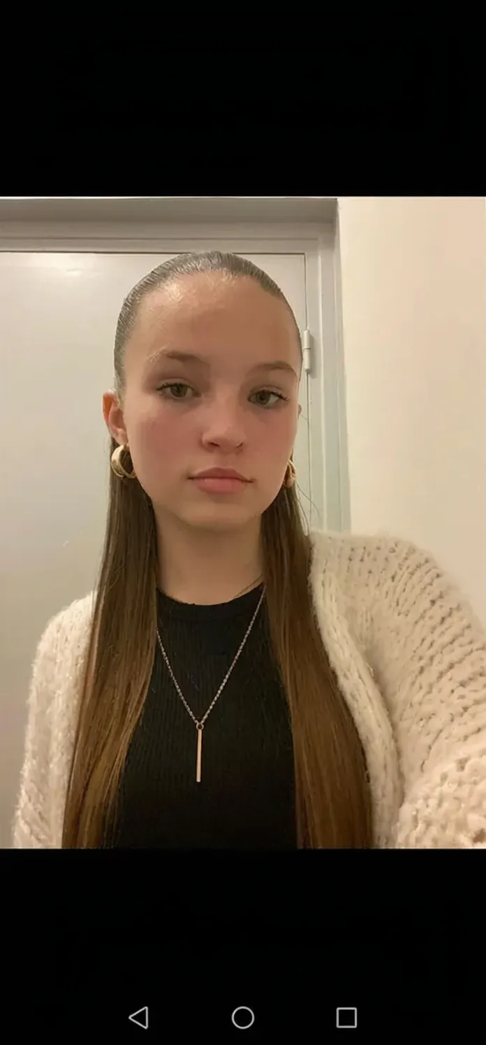 Milnrow, 2023. A young ((((19-year-old)) Maia Allen)), skinny, sitting in a hospital room chair, ((sad expression)), ((((clothings from the 2020s)))), ((hairstyle of the 2020s))