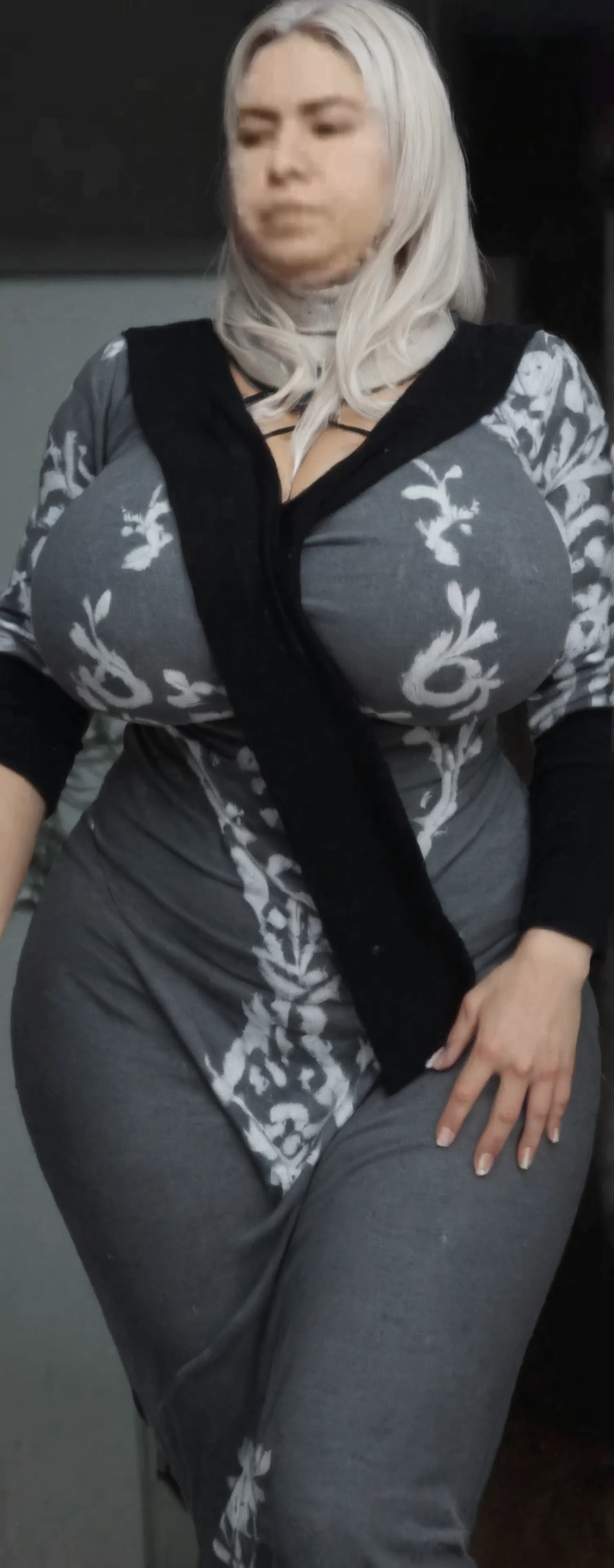 A beautiful and hot almost chubby mature woman.. . who is wearing a patterned dress. and standing at home. A smiling face.