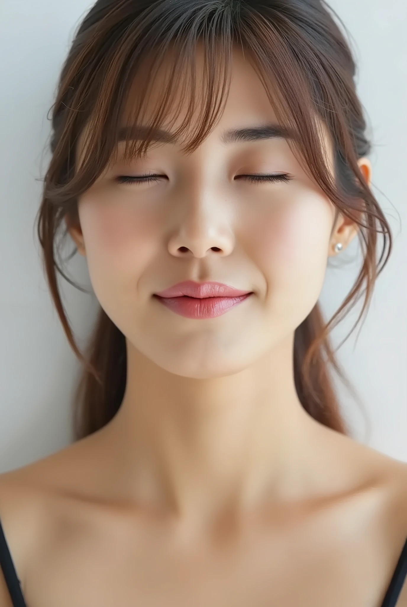ultra-detailed close-up of a beautiful girl, collarbone-up composition, white studio background, soft natural lighting, slightly elevated camera angle (around 35 degrees), full face and head visible in frame, chin slightly raised, eyes gently closed, deeply affectionate smile, cheeks and ears flushed, dreamy, blissful, euphoric expression, mouth puckered and protruding with a rounded kiss shape, glossy moist lips with shimmering highlights, soft lips reflecting light, extreme focus on lips, inviting kiss pose, longing expression, desperate affection, dere-dere mood, hands behind her back and not visible, natural skin texture with visible peach fuzz, matte facial skin, black camisole strap visible, soft head tilt, bokeh background and soft facial contour blur to emphasize lips, overflowing with affection and dazed joy