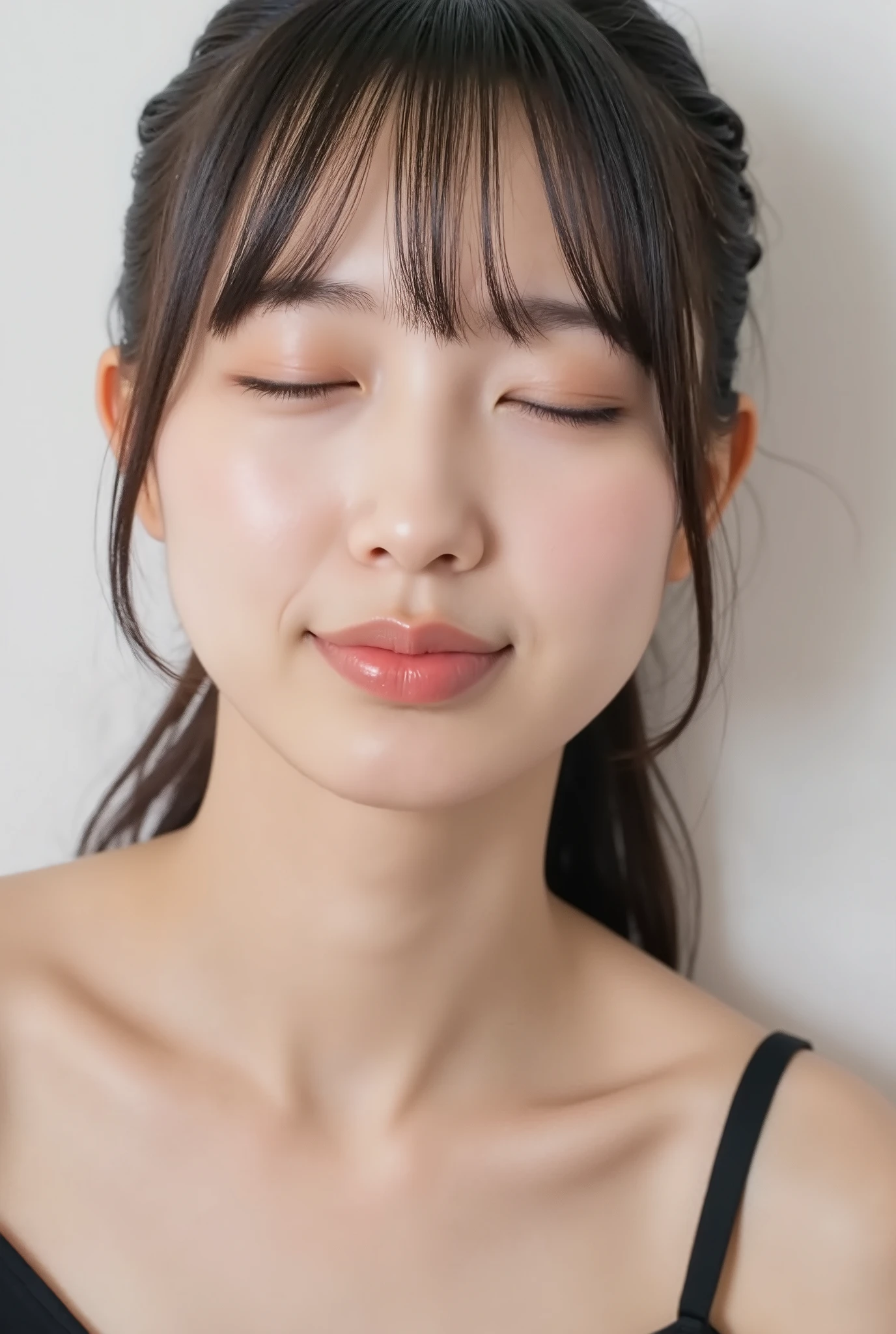 ultra-detailed close-up of a beautiful girl, collarbone-up composition, white studio background, soft natural lighting, slightly elevated camera angle (around 35 degrees), full face and head visible in frame, chin slightly raised, eyes gently closed, deeply affectionate smile, cheeks and ears flushed, dreamy, blissful, euphoric expression, mouth puckered and protruding with a rounded kiss shape, glossy moist lips with shimmering highlights, soft lips reflecting light, extreme focus on lips, inviting kiss pose, longing expression, desperate affection, dere-dere mood, hands behind her back and not visible, natural skin texture with visible peach fuzz, matte facial skin, black camisole strap visible, soft head tilt, bokeh background and soft facial contour blur to emphasize lips, overflowing with affection and dazed joy