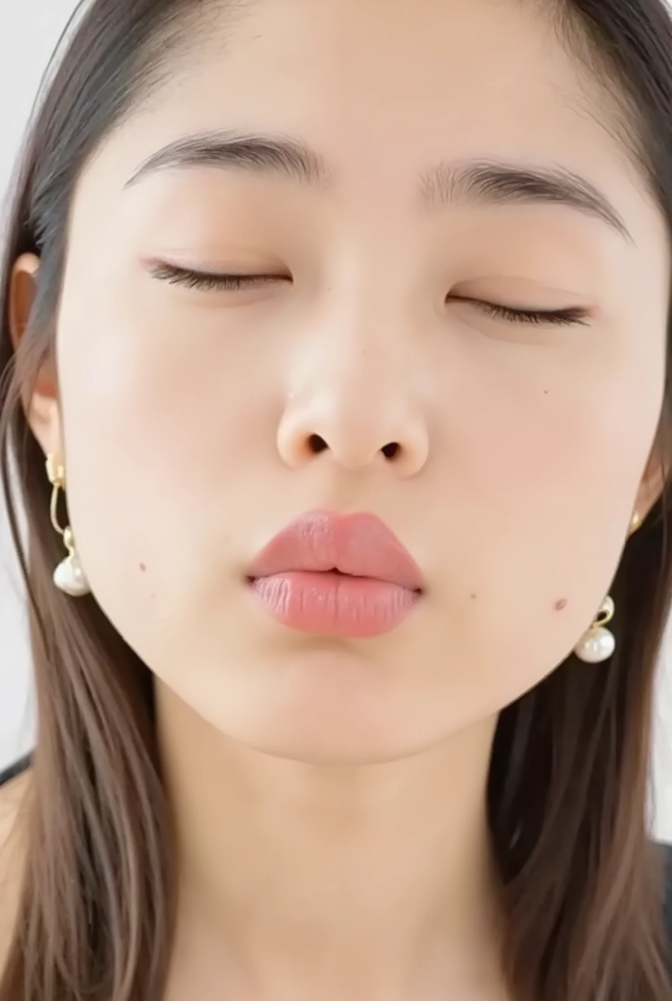 ultra-detailed close-up of a beautiful girl, collarbone-up composition, white studio background, soft natural lighting, slightly elevated camera angle (around 35 degrees), full face and head visible in frame, chin slightly raised, eyes gently closed, deeply affectionate smile, cheeks and ears flushed, dreamy, blissful, euphoric expression, mouth puckered and protruding with a rounded kiss shape, glossy moist lips with shimmering highlights, soft lips reflecting light, extreme focus on lips, inviting kiss pose, longing expression, desperate affection, dere-dere mood, hands behind her back and not visible, natural skin texture with visible peach fuzz, matte facial skin, black camisole strap visible, soft head tilt, bokeh background and soft facial contour blur to emphasize lips, overflowing with affection and dazed joy