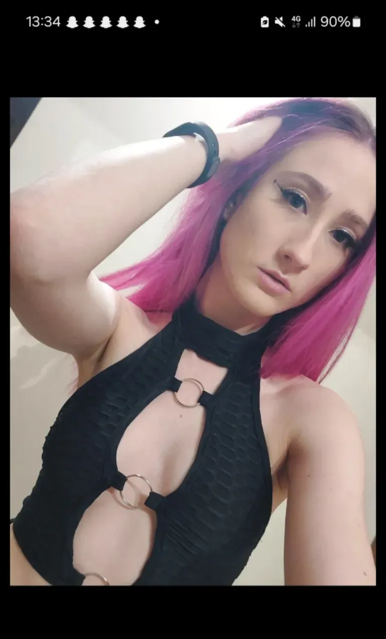 Photograph of an anorexic emaciated extremely skinny Danish female model, big smile, teeth are showing, medium sized breasts, lingerie is blue, looking back toward camera over left shoulder, back is showing, buttocks is showing, black 10" wide choker on neck, brilliant pink hair with ponytail, bright red lipstick, heavy black mascara eye lashes, incredibly skinny body, extremely skinny body, emaciated body, tiniest waist ever, well-defined collar bones, well-defined hip bones, well-defined ribcage, extremely skinny arms and legs, weak and fragile body, masterpiece, anatomically correct, textured skin, super detail, high details, high quality, best quality.