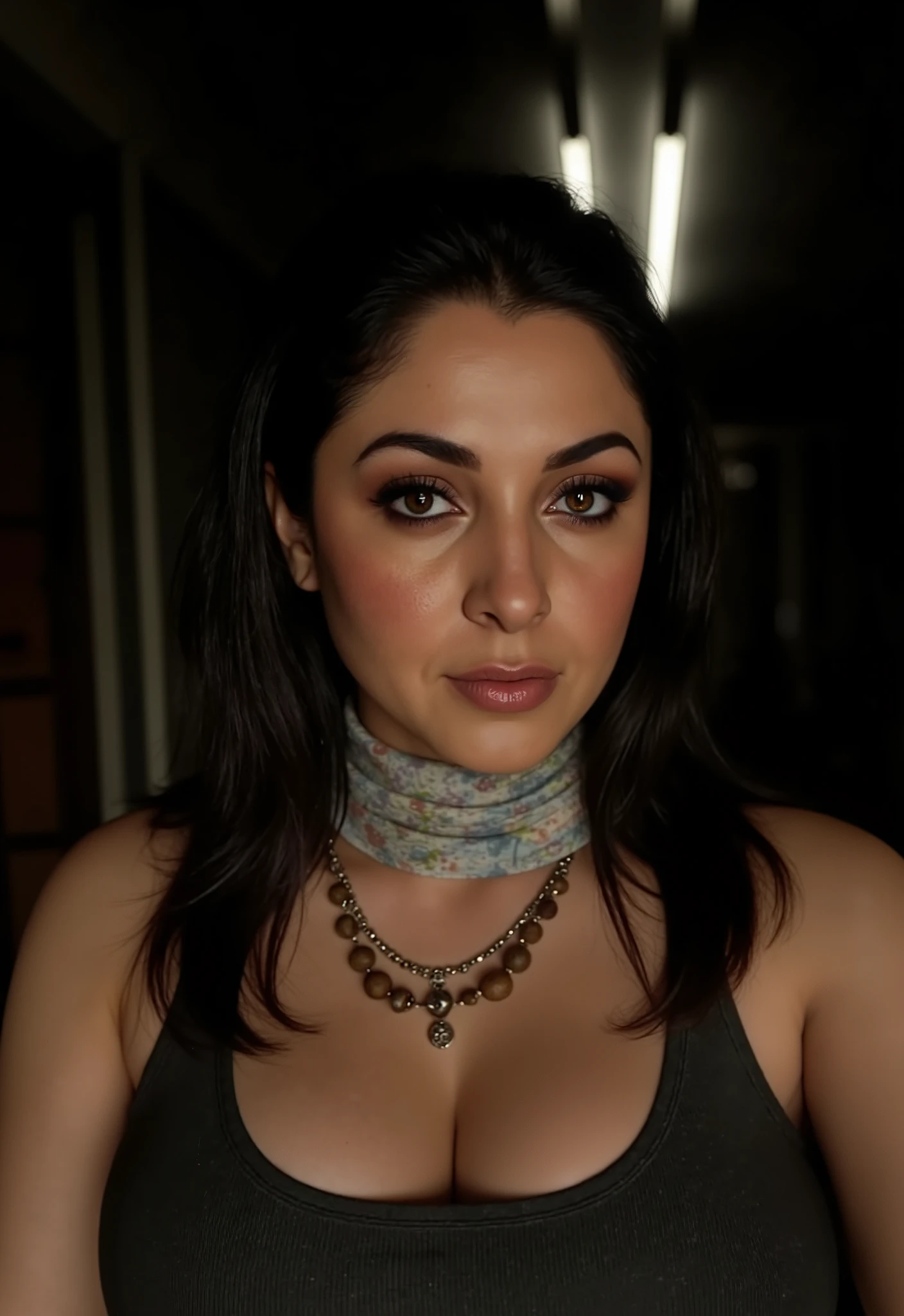 
A low-angle, close-up portrait of a woman with dark hair and a serious expression, likely Valeria Garza from a video game. She has dark, straight hair that frames her face and prominent cheekbones. She is wearing a dark tank top and a light-colored, patterned scarf around her neck. There's also a necklace with what appears to be wooden beads or small charms visible. Her gaze is direct and intense, looking slightly downwards towards the viewer. The lighting suggests a dramatic effect, with some light coming from above and behind her, highlighting her features against a dark, out-of-focus background.