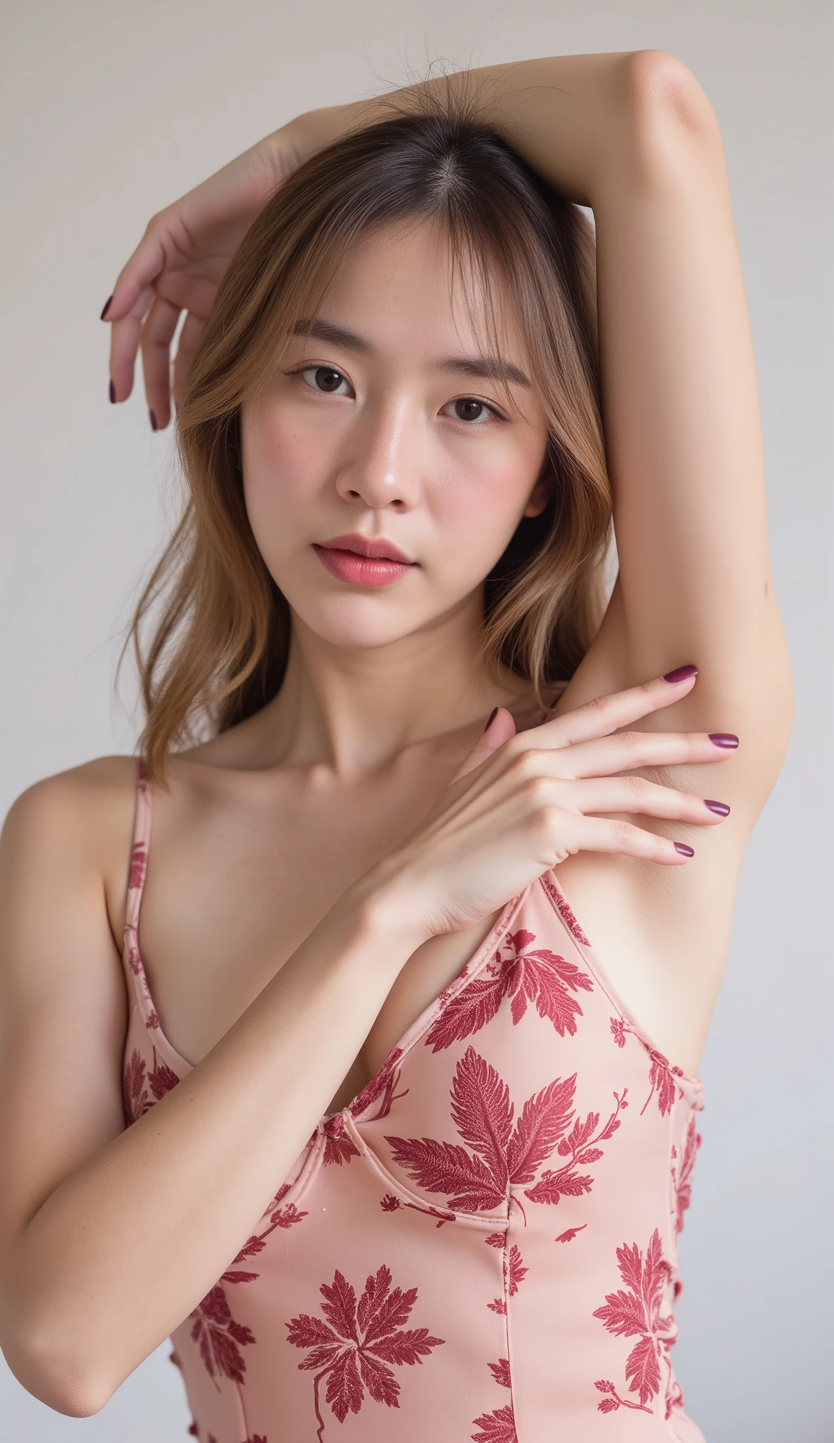 Asian-style young woman that exude an alluring charm. Her soft pink lips are slightly parted, adding a delicate touch to her look. She has long, light brown wavy hair that enhances her sweet and charming appearance. She poses with one arm raised, revealing wrinkles but no-hair armpit, while her other hand gently touches her armpit with two fingers extended, creating a sexy vibe. Her nails are painted a burgundy, which contrasts subtly with her outfit that has hints of burgundy, adding a striking element to her overall look. The background is kept simple and plain, ensuring the focus remains on her. The image combines a sense of sweetness and allure, making it captivating and sexy.