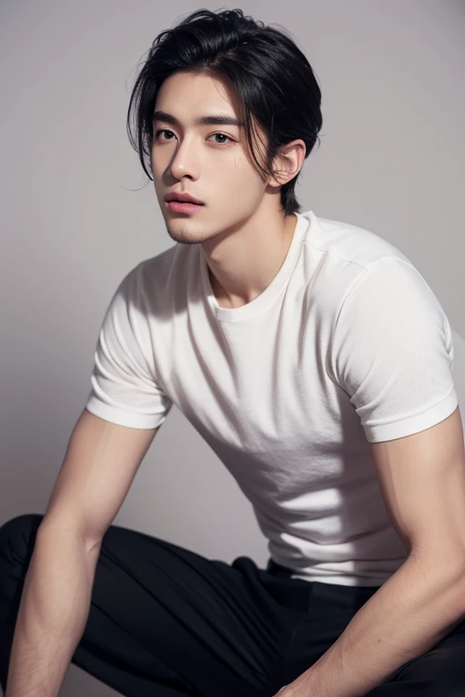 Create a 4K black and white image of a man with short wavy hair, wearing a white t-shirt and black pants sitting, leaning against a gray wall, alone and with no one by his side