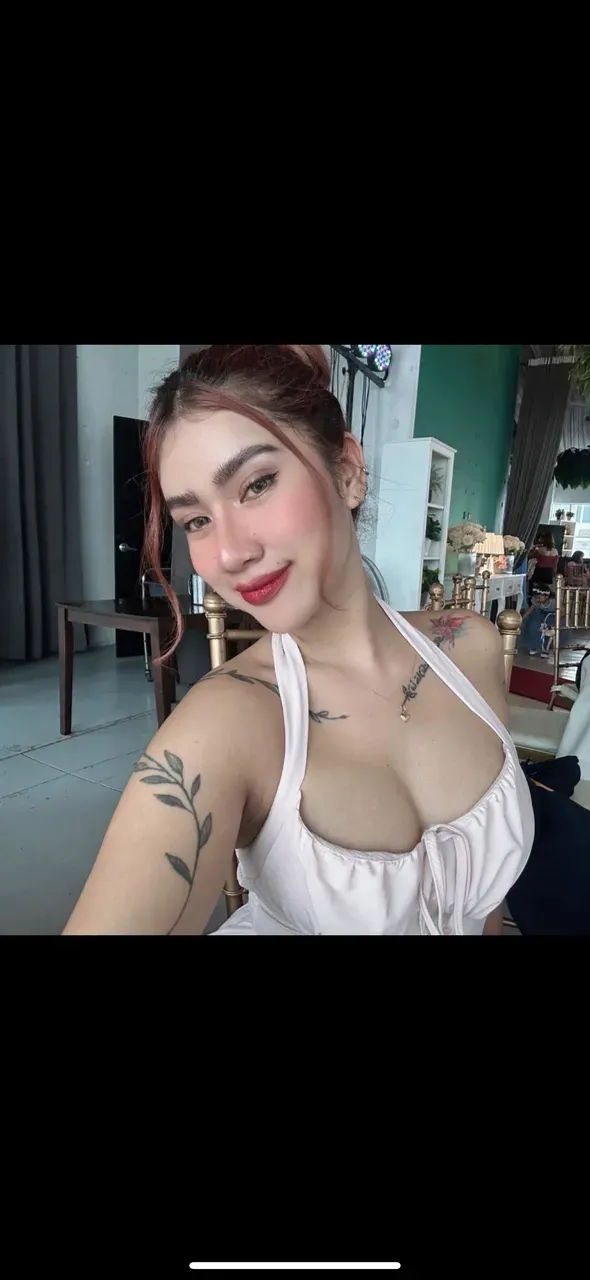 there is a woman with tattoos on her chest sitting on a bench, 2 7 years old, top-quality, Photorealsitic, ​masterpiece, 8K, Hi-Res, solo, 1girl, (((infp young woman))),sixteen years old、full bodyesbian、(big beautiful tits), ((Look at viewers)), (look at a camera), ((Various hairstyles close to long)）、Perfect straight black hair、((With bangs))、 (profetional lighting), Highly detailed bright face、Gentle thai girl、lovely smile、Small cleavage