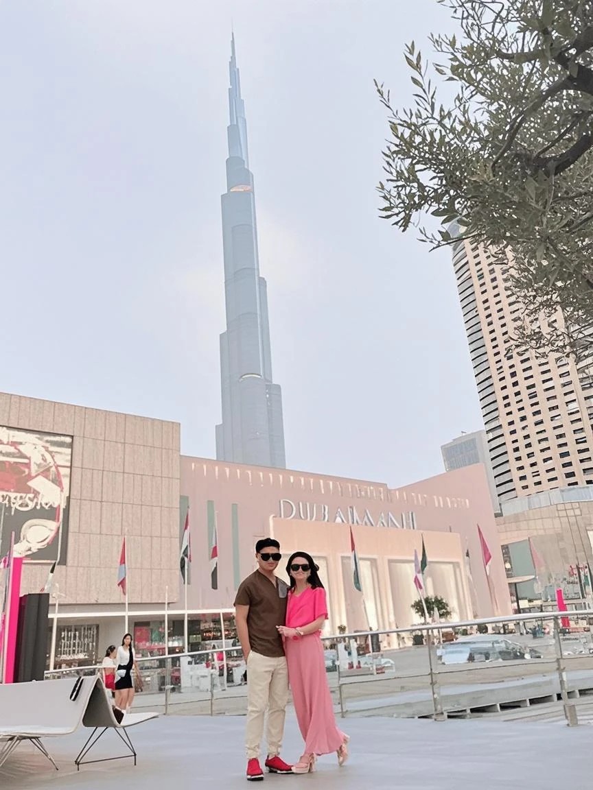 araffes take a selfie of a romantic Indonesian couple in front of the petrona towers wearing cool coats and boots ootd selebgram, with towers, twin towers, kuala lumpur, with photos of their long vacation, views, with sunglasses, real!!!, tourist destinations, skyscrapers sky in the background, selfie photo, taken while go pro hero8, instagram picture, lovely couple