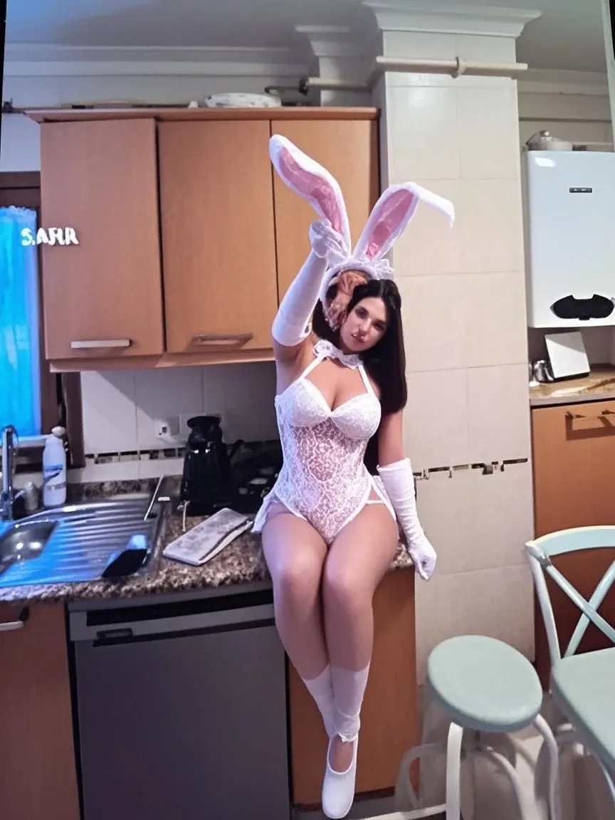 a cute teenage girl, about 160cm tall, brown eyes, in a white dress with bunny ears and a basket of eggs, photo from behind, picture from behind, 🍑, thick, photo taken from behind, view from behind, Instagram model, back view, looking from behind, ultrarealistic sweet bunny girl, bunny girl, brunette goddess, with bunny ears, beautiful brunette girl, fully clothed, little cleavage exposure, smile on her face, long curly black hair, masterpiece, best quality, ultra quality, high quality, highest, ultra highest, absurdness, 4K, 8K, 16k, hyper detailed, intricate detailed, amazing shading, high contrast, realistic, photo realistic, photography, super fine illustration, foreshortening, perfect anatomy, correct anatomy, perfect proportion, perfect face, perfect hands, perfect legs, perfect fingers, very curvy hour glass shape, Kim Kardashian curvy, huge breasts, indoor photoshoot, easter celebration,