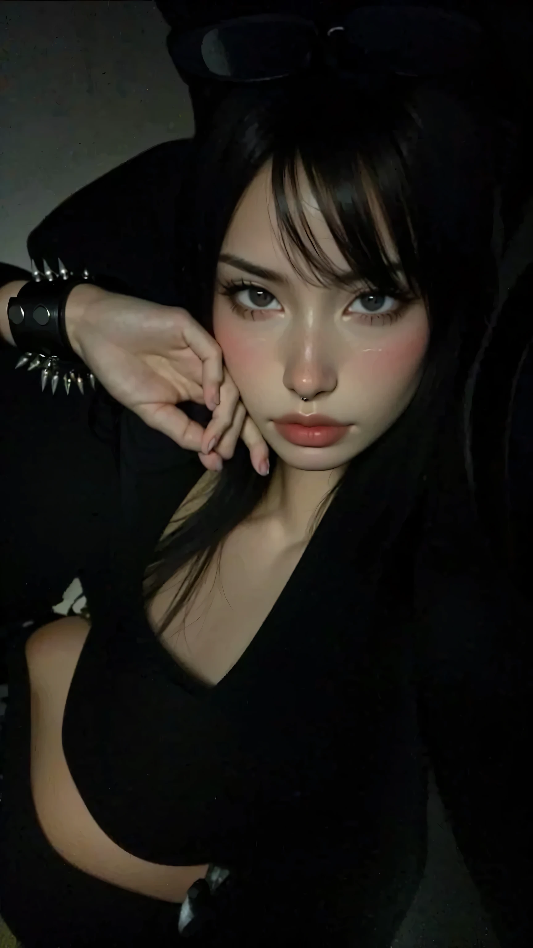 woman with straight black hair and blue eyes with slit-shaped pupils, with a black dress in a modern wusrto sitting on the bed.