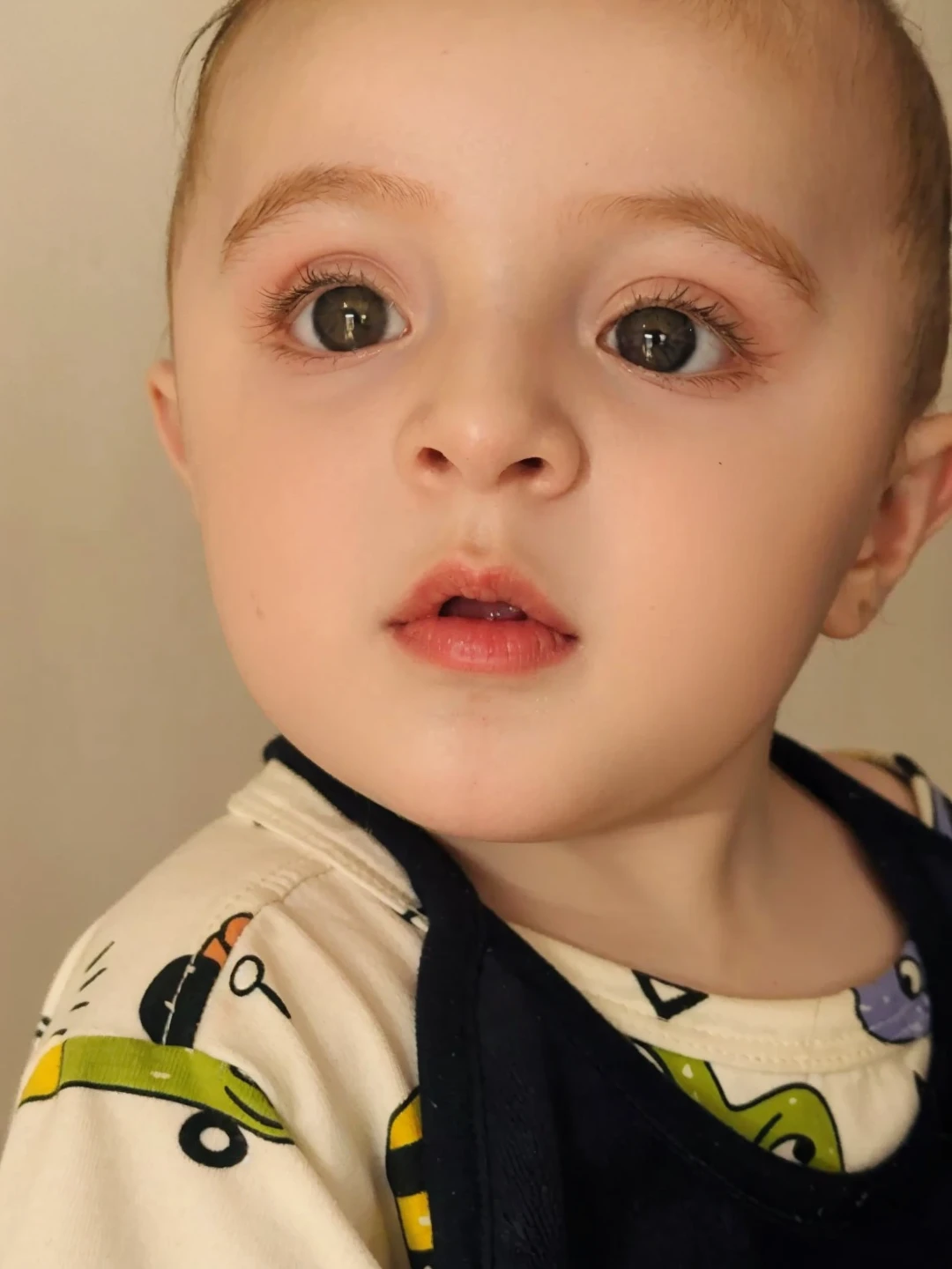 there is a baby that is sitting in a stroller, serious face, Serious expression, with serious face expression, serious focussed look, serious sad look in his eyes, intense expression, serious look, proud serious expression, cara de, cara fofa jovem, muito muito bonito rosto, screaming at the camera, olhar horrorizado em seus olhos