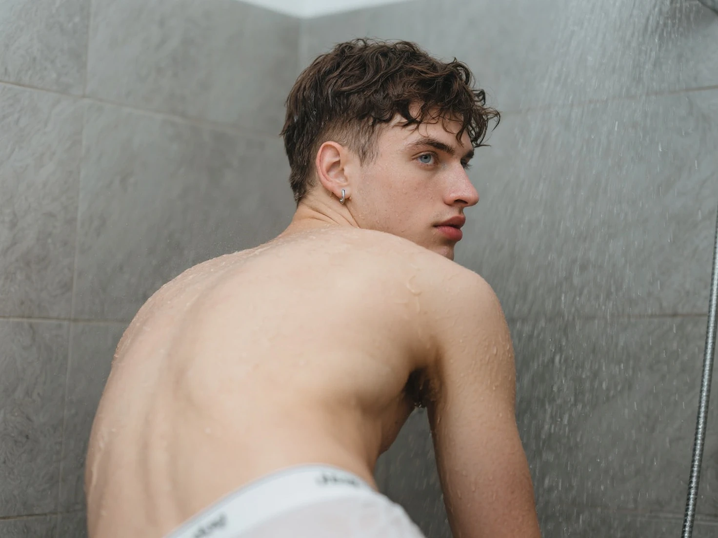 A picture of an 18-year-old boy taking a shower while wearing an undershirt