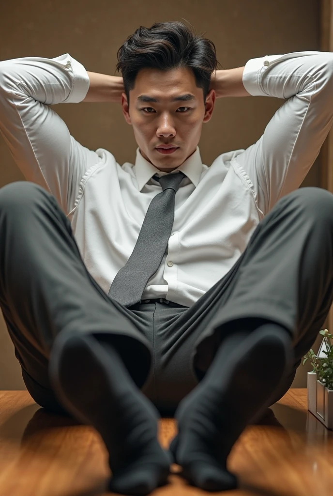 Teen sexy guy is sitting on a chair while placing his feet on the top of the face of a lying guy