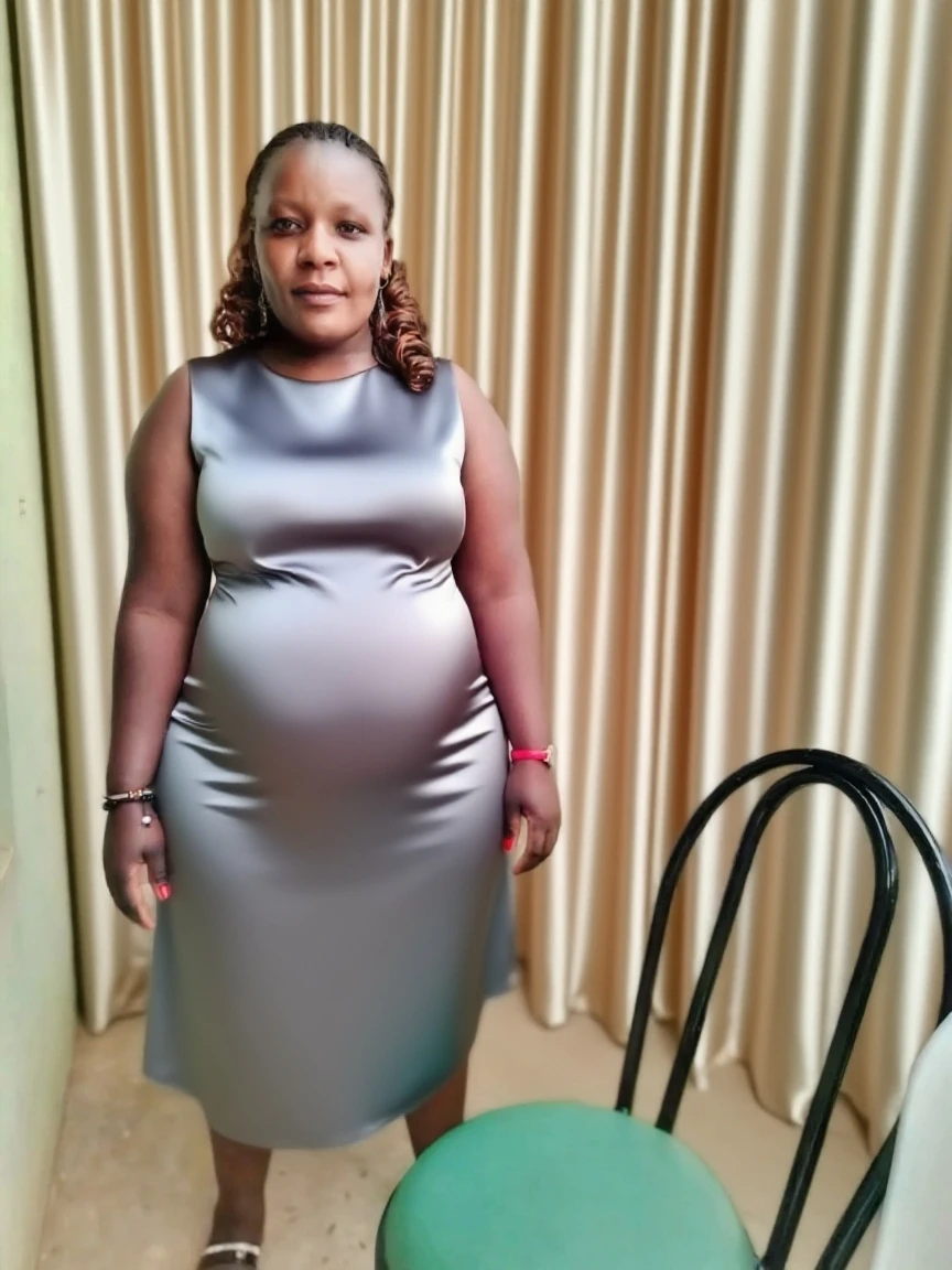 Extremely Hyperpregnant Ghanaian woman with huge belly wearing a dress