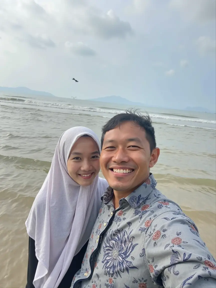 very detailed and realistic photos, HD quality, 4K, A married couple, wearing glasses, facing the Camera, Indonesian man and woman, 50 years old, black hair, the man is a bit thin, 170 cm tall, wearing casual clothes, the woman is wearing a headscarf, fat, 165 cm tall, the photo position is facing the camera, they are riding a luxury private yacht with an open roof on a seashore with a background view of small islands that are very beautiful and exotic with very clear sea water, a large eagle appears to be flying very close to their ship. morning atmosphere with the sun still looking reddish in the sky.