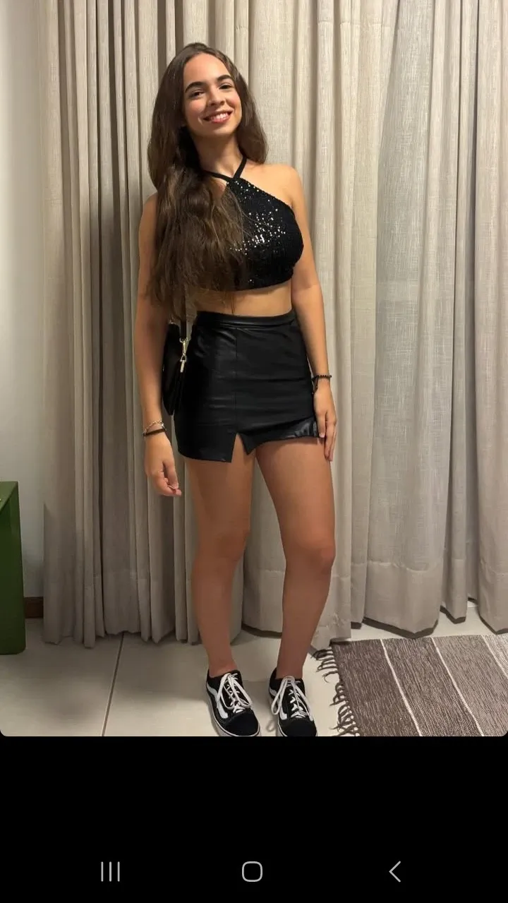 Photo of an 18 year old Mexican girl, She is a very beautiful and very sensual girl. She is wearing a short black skirt. She is taking a selfie in front of a mirror.