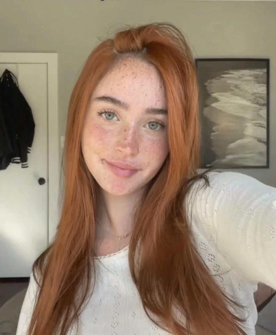 Casual photo of a 19-year-old redhead with Aquamarine eyes , eating a healthy breakfast, dressed in half-uncovered blue pajamas, at a table with her father Of Brown hair sitting on the other side of the table, in a suit