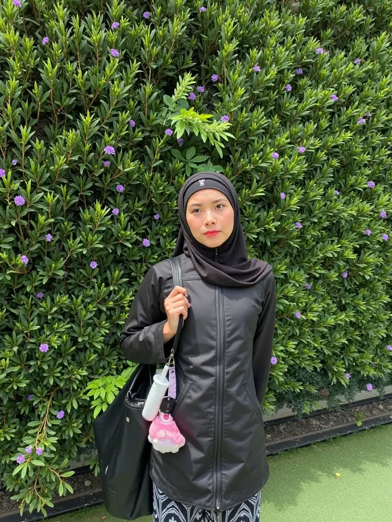 A girl is in a purple 
burqa, the whole burqa is spread out, wearing a burqa and holding an iPhone style 
in her hand, and she is sitting in chair 
with ground and her shirt 
written in the style (Hafsa).