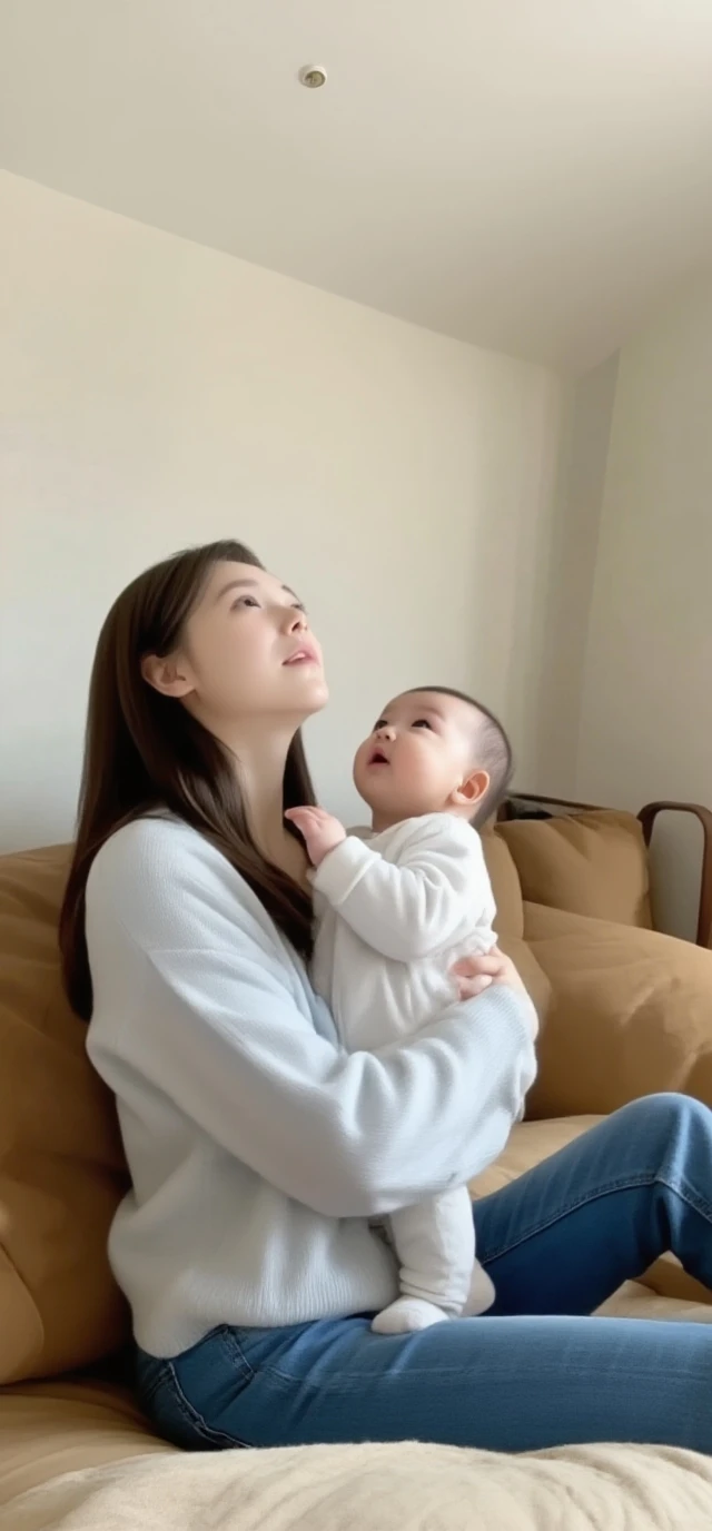 1 year old baby, help by in her mother's arm, it's a living room shot, with a beige color wall, and different art pieces attached to the wall. 