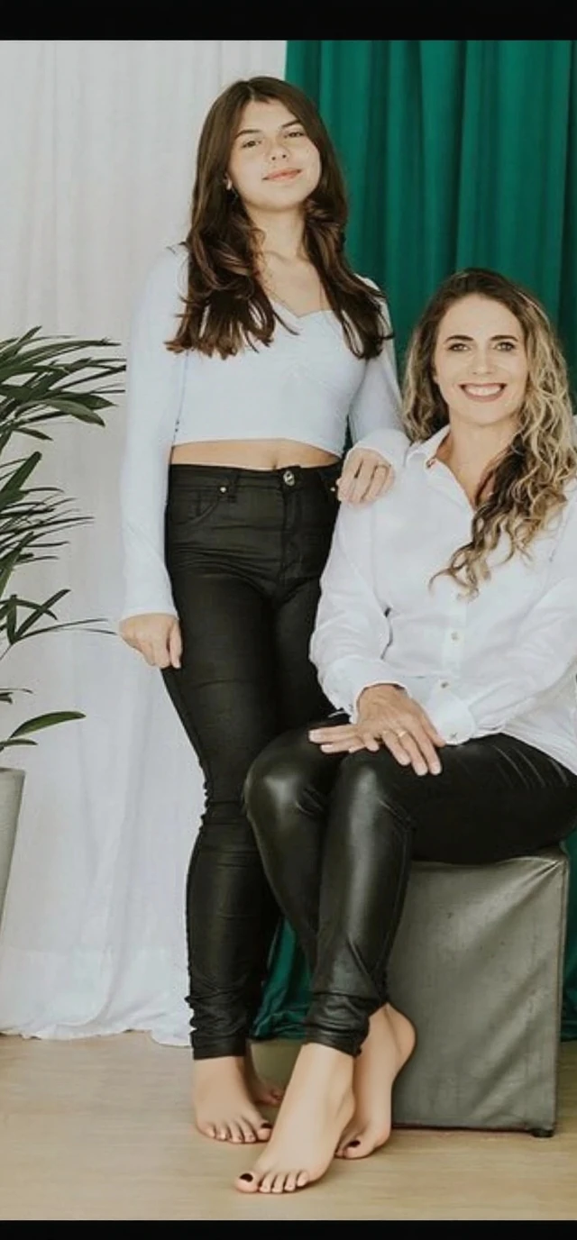 A mother with her 10 year old daughter, wearing a tight leggins, spread her legs in the floor of a living room.