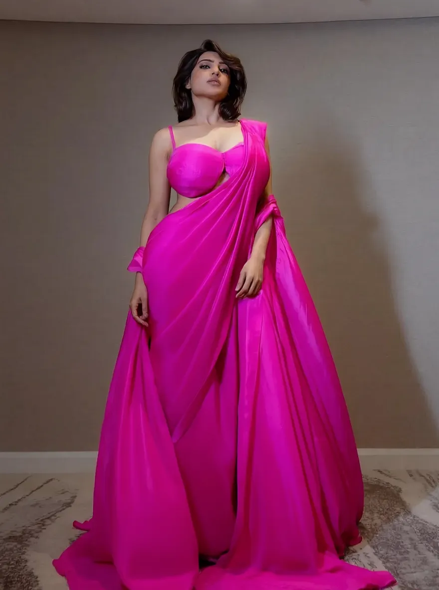 Beautiful indian woman in vey long translucent pink satin dress