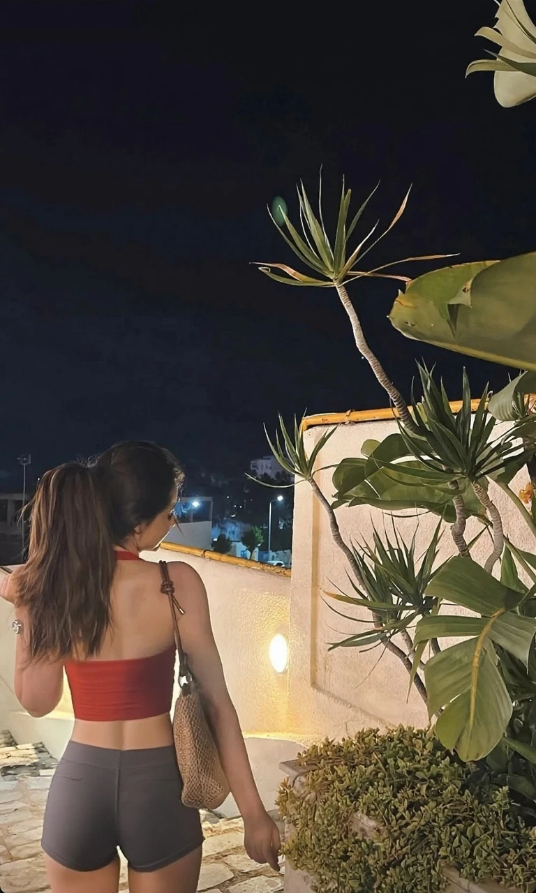 Woman in a black sexy just slit dress in a place at night
