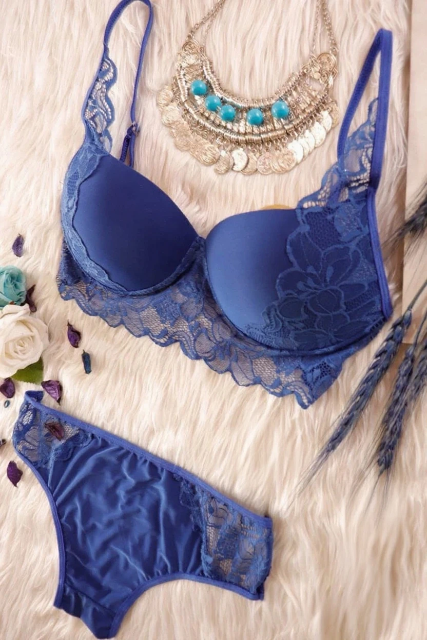 Teenage girl, blue curly hair, gorgeous face, clear jaws and high cheekbones, sharp blue eyes and bent eyebrows, minimal mascara makeup, natural looking foundation and mascara, floral print bras, straight poses with her head tilted slightly to the right, her posture upright shoulders to back, dressing room background, 30k, exquisite