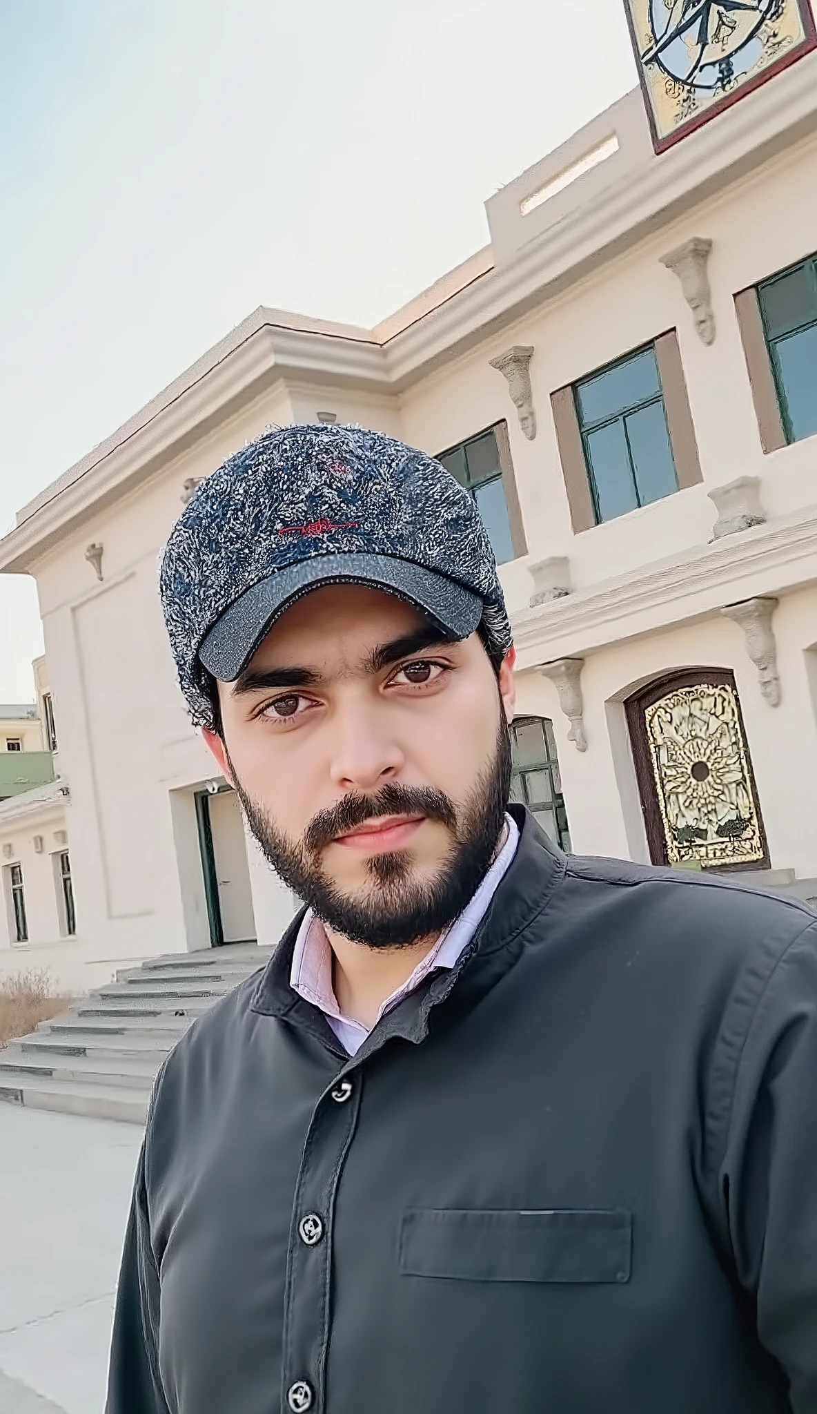 there is a man standing in front of a building with a clock on it, khyzyl saleem, kyza saleem, ash thorp khyzyl saleem, very clear picture, very very low quality picture, ayan nag, uploaded, roshan, by Riza Abbasi, sayem reza, riyahd cassiem, portait photo profile picture