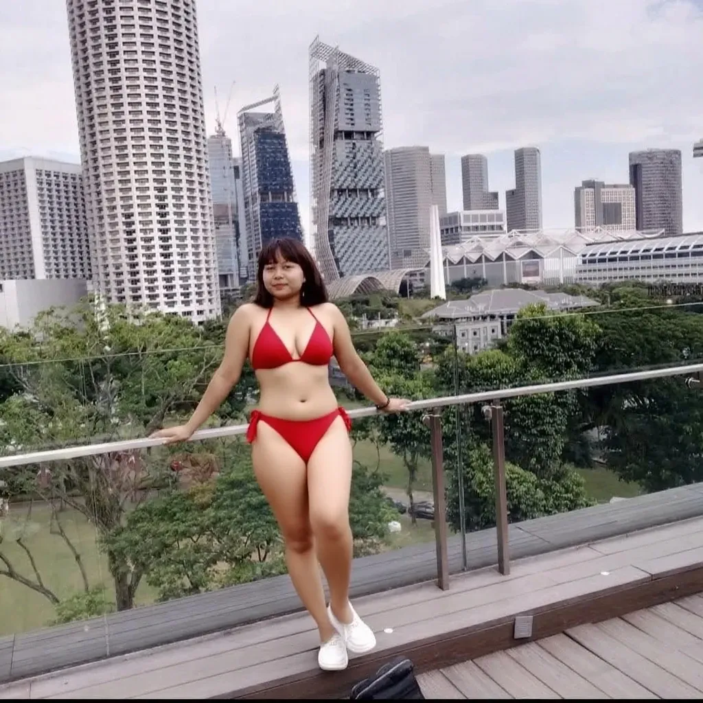 a korean woman wearing red  look, whose height is 10000000 kilometers, at the nano-sized miniature endless city of micro-sized endless continent world, she kneel down on top of a lot of nano-sized buildings which are much smaller than her, she feel happy and enjoy
