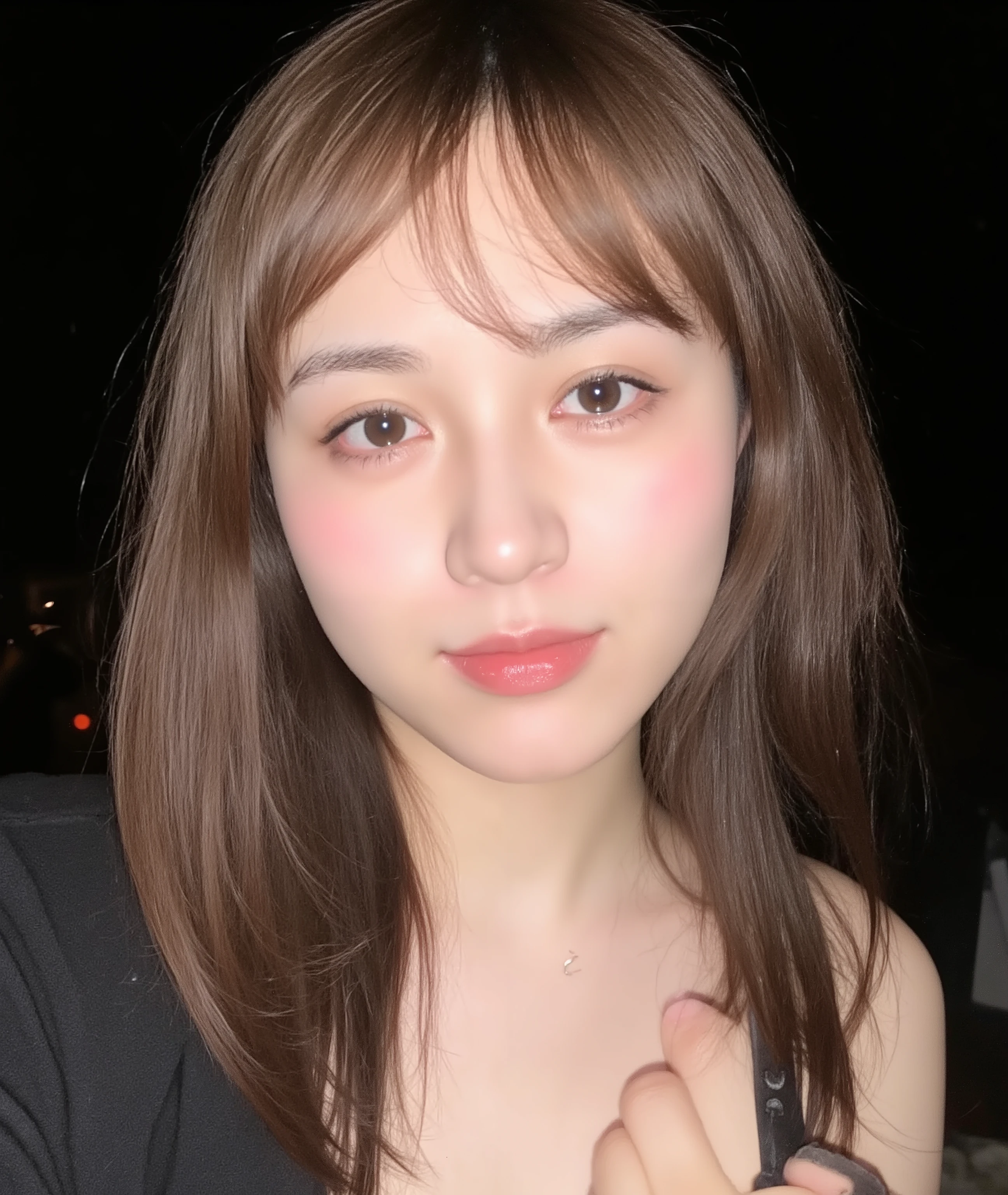 The image is a close-up photograph of a young Asian woman with a fair complexion. Her face dominates the frame, occupying the majority of the image, with her eyes, nose, and lips prominently visible. She has large, almond-shaped eyes with long, thick eyelashes, and her skin is smooth and soft. Her lips are full and slightly parted, revealing a natural, rosy hue. She wears a small silver stud earring in her left ear, adding a subtle touch of personal style.

Her hair is long, dark brown with subtle highlights, and it partially covers her forehead, giving a slightly tousled, casual look. The background is out of focus, but it appears to be a dark, possibly indoor setting, which emphasizes her face and provides a stark contrast to her light complexion. She is wearing a black garment, possibly a top or a sleeve, which is visible at the bottom of the image. The overall mood of the photograph is intimate and personal, capturing a candid moment with a natural, unfiltered aesthetic.