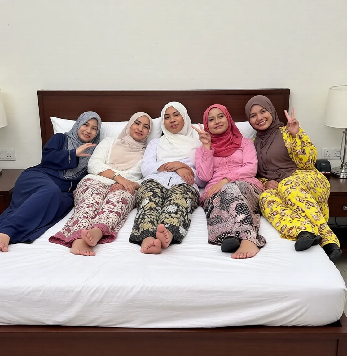 a group of malay girls in pajamas and pastel color hijab having a pillow fight between them in a tatami room with futons, pillows flyin, smile, looking at viewer, best quality, high resolution, extremely detailed, professional, illustration, trending on pixiv, masterpiece, cinematic lighting, anime art style,