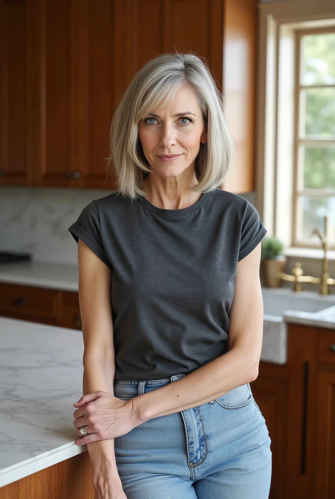 Commanding lifestyle portrait of a 60-year-old woman embracing youthful fashion with champagne grey blunt cut bob and deep side-swept bangs partially covering one eye, thin face with expressive blue eyes showing depth and character, natural aging with distinguished crow's feet, wearing an age-defying fitted faded dark grey t-shirt with cap sleeves, tucked neatly into light-washed skinny tight flared jeans that accentuate her figure, black boots completing the contemporary look, posed confidently against a marble kitchen island with hip slightly cocked, morning sunlight filtering through windows creating dimensional lighting, photorealistic style capturing the bold contrast between her mature features and trendy clothing choices, warm-toned kitchen interior with wooden elements and brass accents, professional photography with shallow depth of field, 85mm lens, f/2.0 aperture