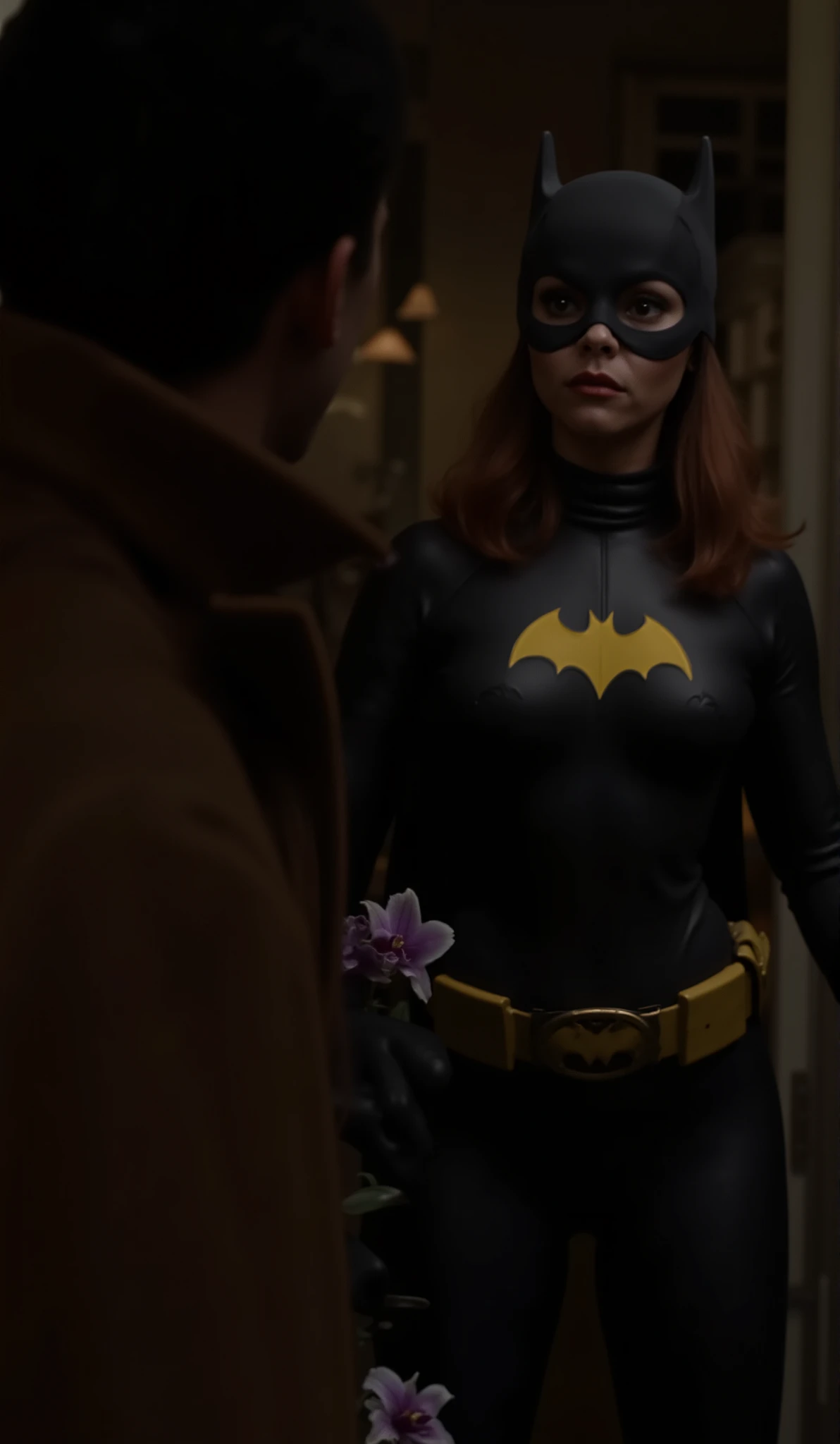 Dramatic lighting, dark shadows, technicolor film still, Waist level shot, cowboy shot, chtistina ricci with dark red hair dressed as Batgirl, she is in crystal clear focus, wearing a dark charcoal gray rubber , batgirl symbol on the , wearing a batgirl mask and cowl, and matching gloves, she stands in the doorway of her apartment, her knees close together, one foot in front of the other, attractive, alluring,  greeting a strange man wearing a brown trenchcoat, (((she looks at the strange man's face, her face expressionless, as though she is hypnotized))),  the stranger holds a purple and white orchid in his hand. He holds the flowers close to his body.  The mans back is facing the viewer, the mans face is out of view, low angle shot looking up.  The image is focused on batgirl, and the strange man is only seen on the right side of the image, the angle and position of the camera only shows half the mans body, and his head is out of frame at the top,  elevating the sense of mystery