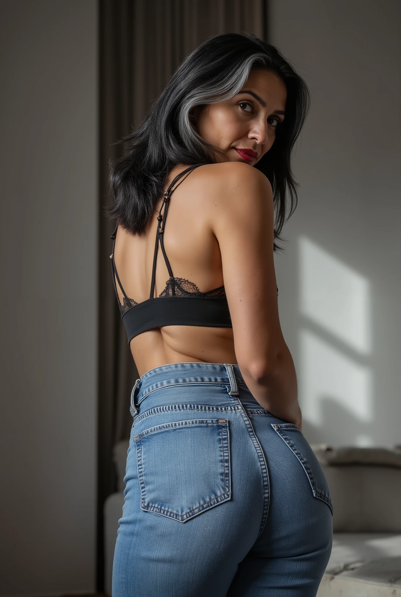 Lowangle,A white european mature woman, 60 years old, stands in jeans, her back to the camera, positioned on the floor directly behind her for a steep straight rear view. The composition is close, visually focusing on the curves of her hips and buttocks, while she glances down over her shoulder to make eye contact with the lens. Condescending expression, crow's feet, glossy red lipstick, looking down on viewer, mom vibes, realistic mature body proportions, aged slightly wrinkled skin. Shoulder length hair dyed black with grey roots, cute hairpins. wearing lace bra. Soft indoor lighting highlights the denim texture and her smooth silhouette, with a blurred minimalist background for emphasis. Cinematic, intimate, stylish feel.