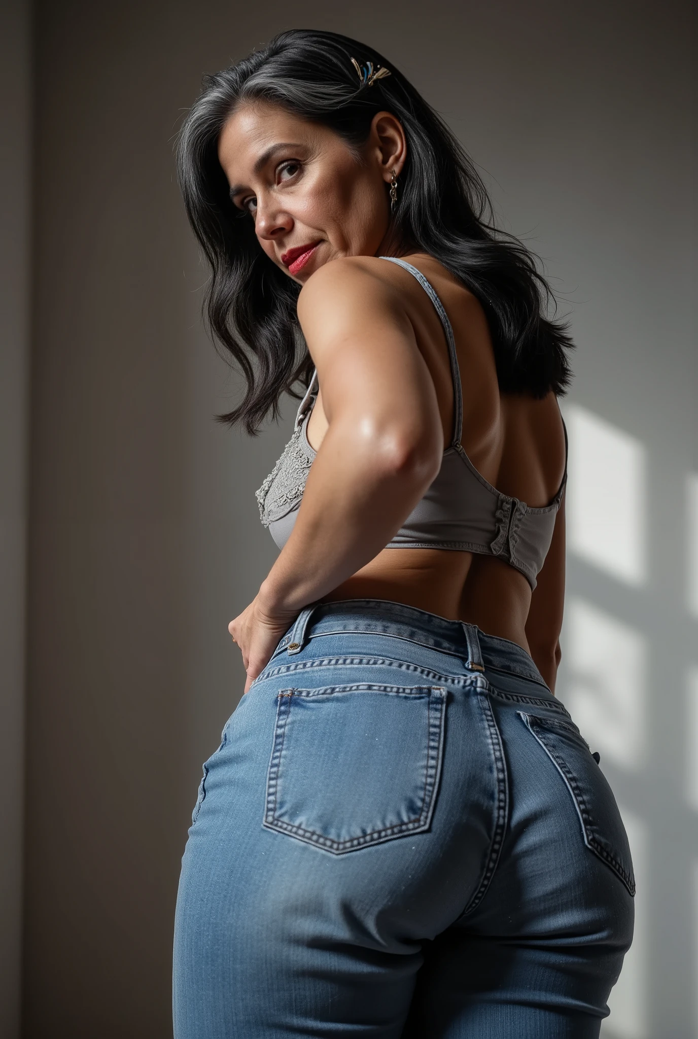 Lowangle,A white european mature woman, 60 years old, stands in jeans, her back to the camera, positioned on the floor directly behind her for a steep straight rear view. The composition is close, visually focusing on the curves of her hips and buttocks, while she glances down over her shoulder to make eye contact with the lens. Condescending expression, crow's feet, glossy red lipstick, looking down on viewer, mom vibes, realistic mature body proportions, aged slightly wrinkled skin. Shoulder length hair dyed black with grey roots, cute hairpins. wearing lace bra. Soft indoor lighting highlights the denim texture and her smooth silhouette, with a blurred minimalist background for emphasis. Cinematic, intimate, stylish feel.