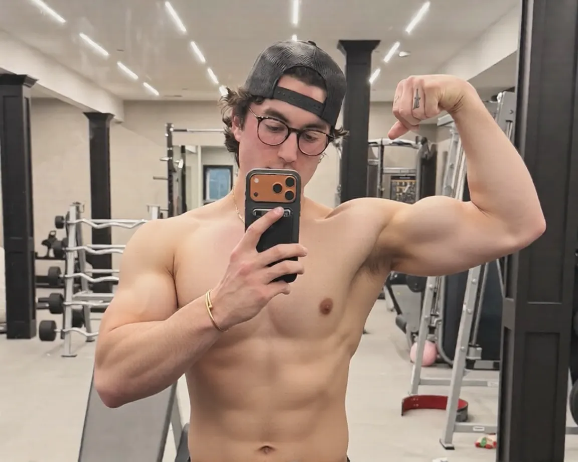 A blond muscular very young teen alpha male bodybuilder, pretty face, thin face, beautiful detailed grey eyes, beautiful detailed lips, extremely detailed eyes and face, long eyelashes, gorgeous brown hair, clear skin, white skin, 18 years old, extremely low body fat, extremely large and defined muscles, impossible proportions, exploding with energy, muscles actively growing, handsome attractive face, ripped abs, veiny arms, broad shoulders, whole body and each muscle flexed, 8 feet tall, posing shirtless, wears black sweatpants, studio lighting, (best quality,4k,8k,highres,masterpiece:1.2),ultra-detailed,(realistic,photorealistic,photo-realistic:1.37),award-winning,highly detailed,intricate,cinematic, dramatic atmosphere,chiaroscuro lighting,striking pose,muscular physique,powerful,intimidating,commanding presence