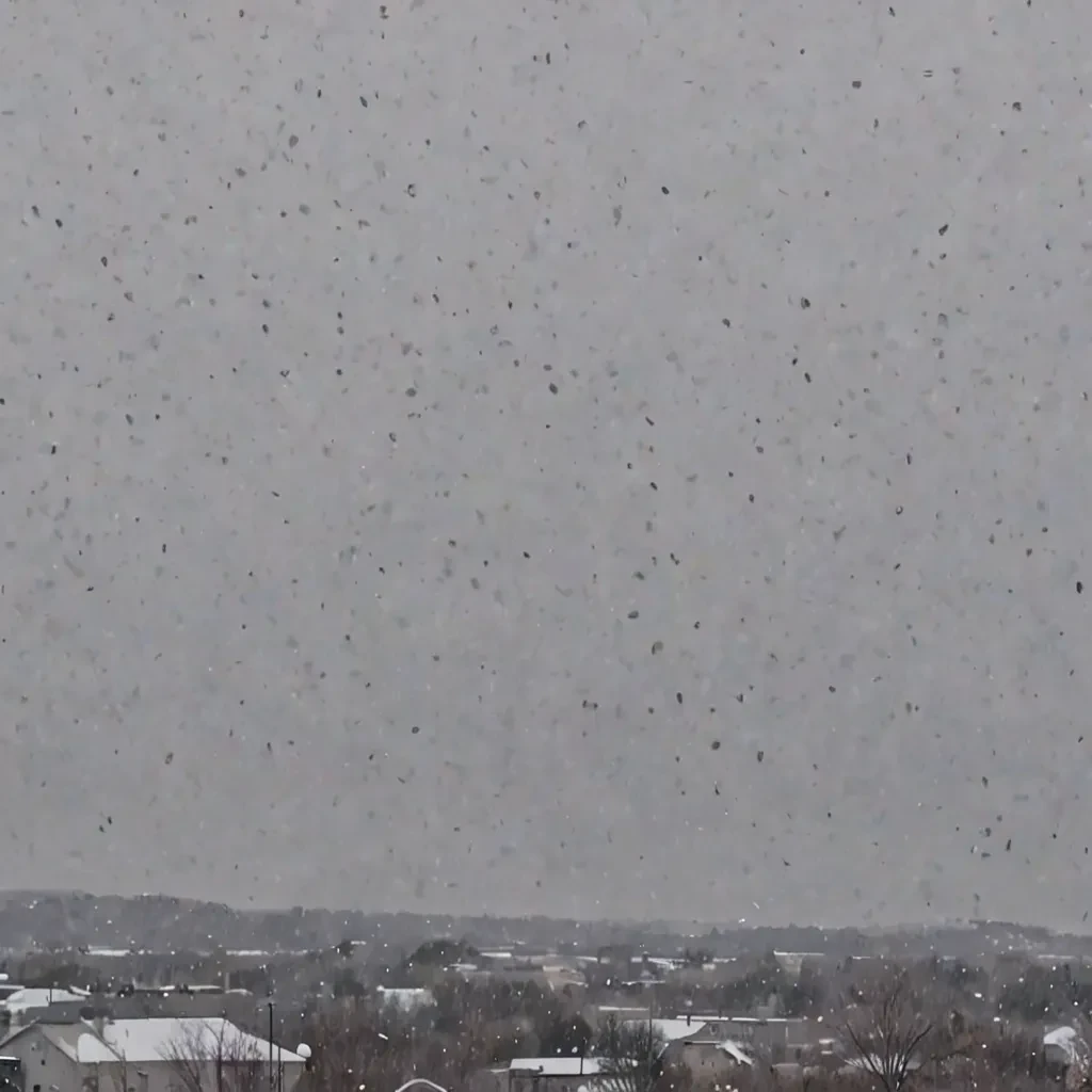 Gray, overcast sky with sleet falling, a mix of rain and snow visible in the air.