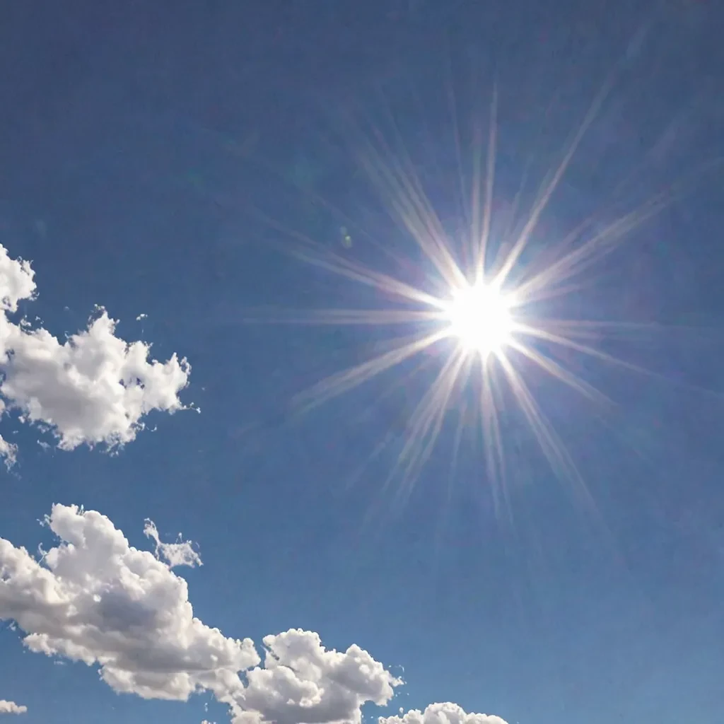 A clear, blue sky with the bright sun shining prominently.